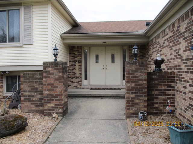14879 Riverside St, Livonia, MI 48154 - view of exterior entry featuring brick siding and a shingled roof