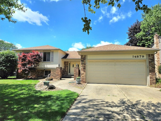 14879 Riverside St, Livonia, MI 48154 - split level home with concrete driveway, a garage, a front yard, and brick siding