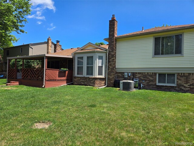 14879 Riverside St, Livonia, MI 48154 - back of house with brick siding, a yard, and a chimney