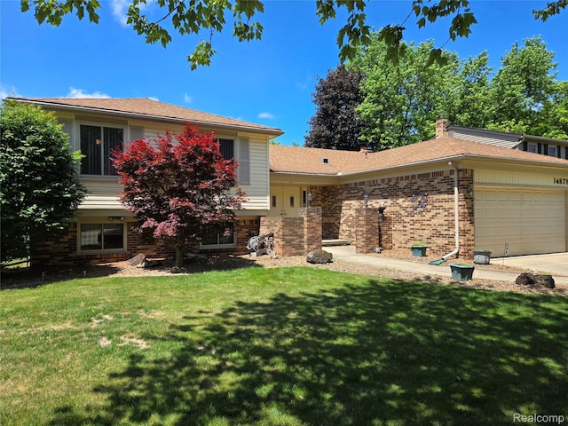14879 Riverside St, Livonia, MI 48154 - split level home with brick siding, a garage, a front lawn, and concrete driveway