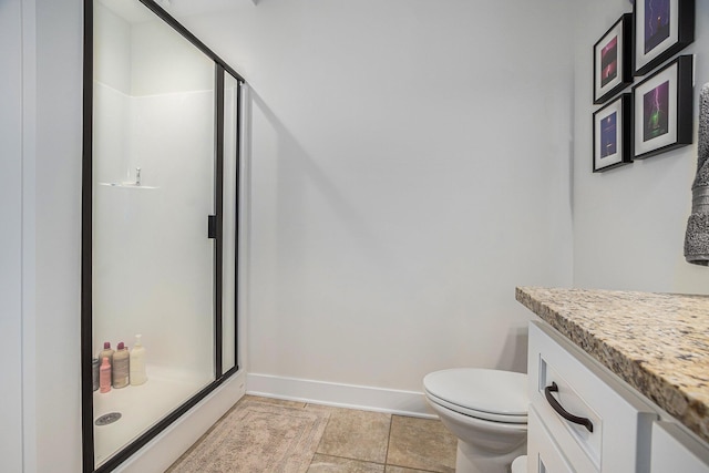 bathroom with a shower stall, vanity, baseboards, and toilet