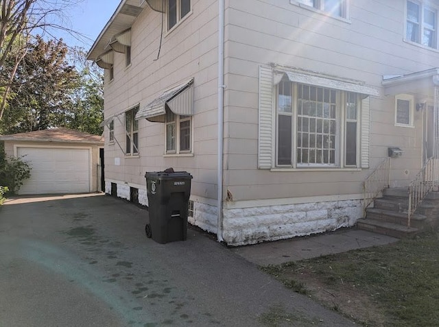 2557 Tiffin St, Flint, MI 48504 - view of home's exterior with an outdoor structure, driveway, and a detached garage