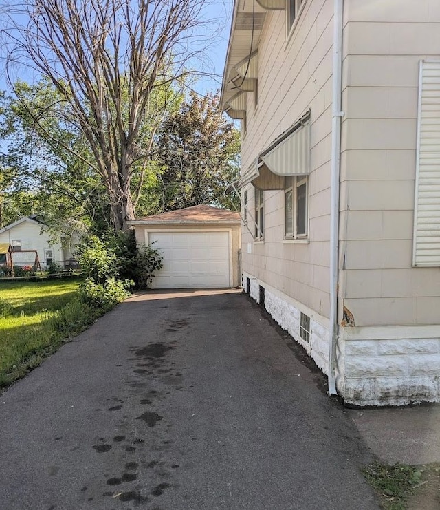 2557 Tiffin St, Flint, MI 48504 - view of side of property with an outbuilding, asphalt driveway, and a detached garage