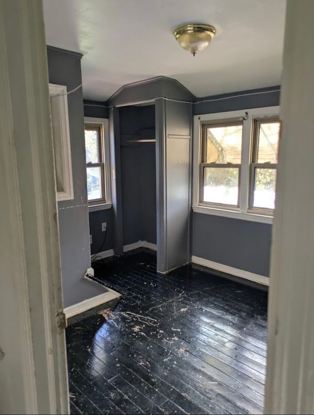 2557 Tiffin St, Flint, MI 48504 - unfurnished bedroom featuring lofted ceiling, dark wood-style floors, and baseboards