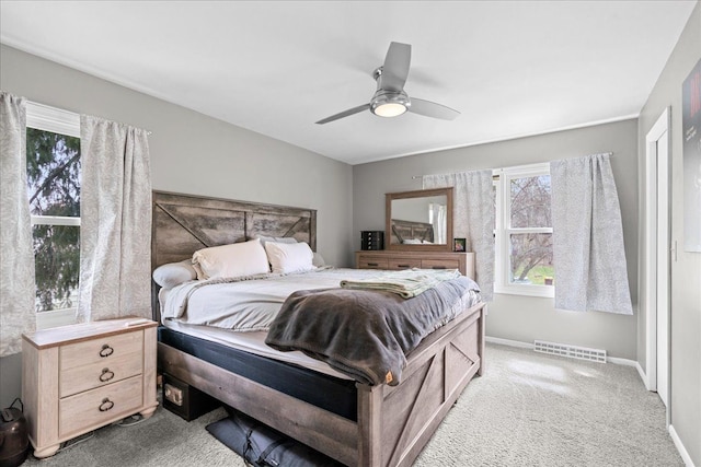 3715 W Hiawatha Dr, Okemos, MI 48864 - carpeted bedroom with visible vents, baseboards, multiple windows, and ceiling fan