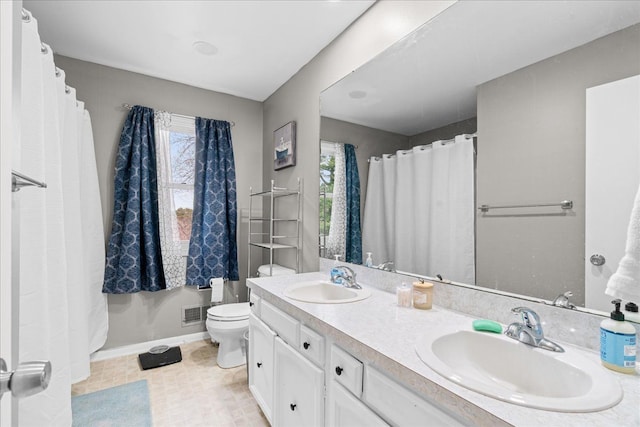 3715 W Hiawatha Dr, Okemos, MI 48864 - full bathroom with double vanity, baseboards, a sink, and toilet