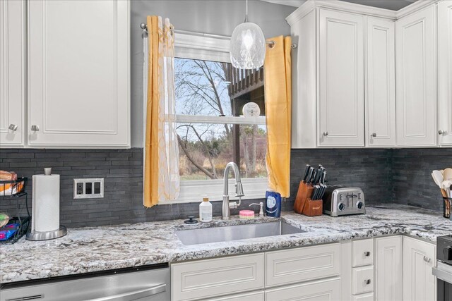 3715 W Hiawatha Dr, Okemos, MI 48864 - kitchen featuring dishwasher, a sink, white cabinetry, backsplash, and light stone counters
