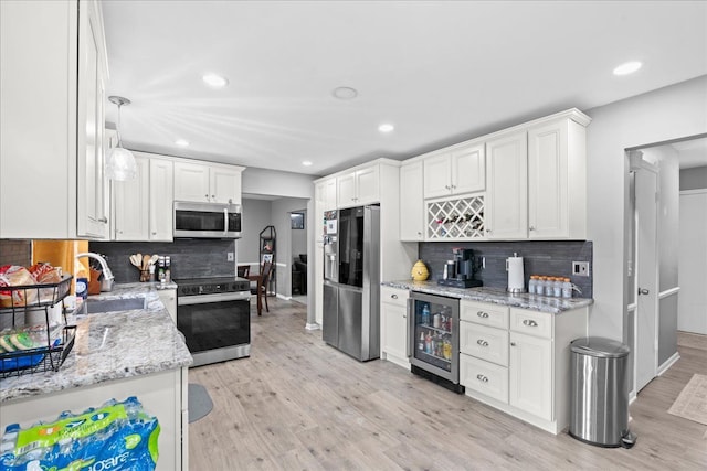 3715 W Hiawatha Dr, Okemos, MI 48864 - kitchen featuring light wood-style floors, decorative backsplash, stainless steel appliances, beverage cooler, and a sink