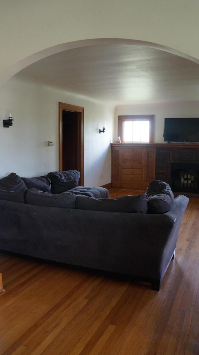 11340 Mccrone Rd, Milan, MI 48160 - living area featuring arched walkways, wood finished floors, and a brick fireplace