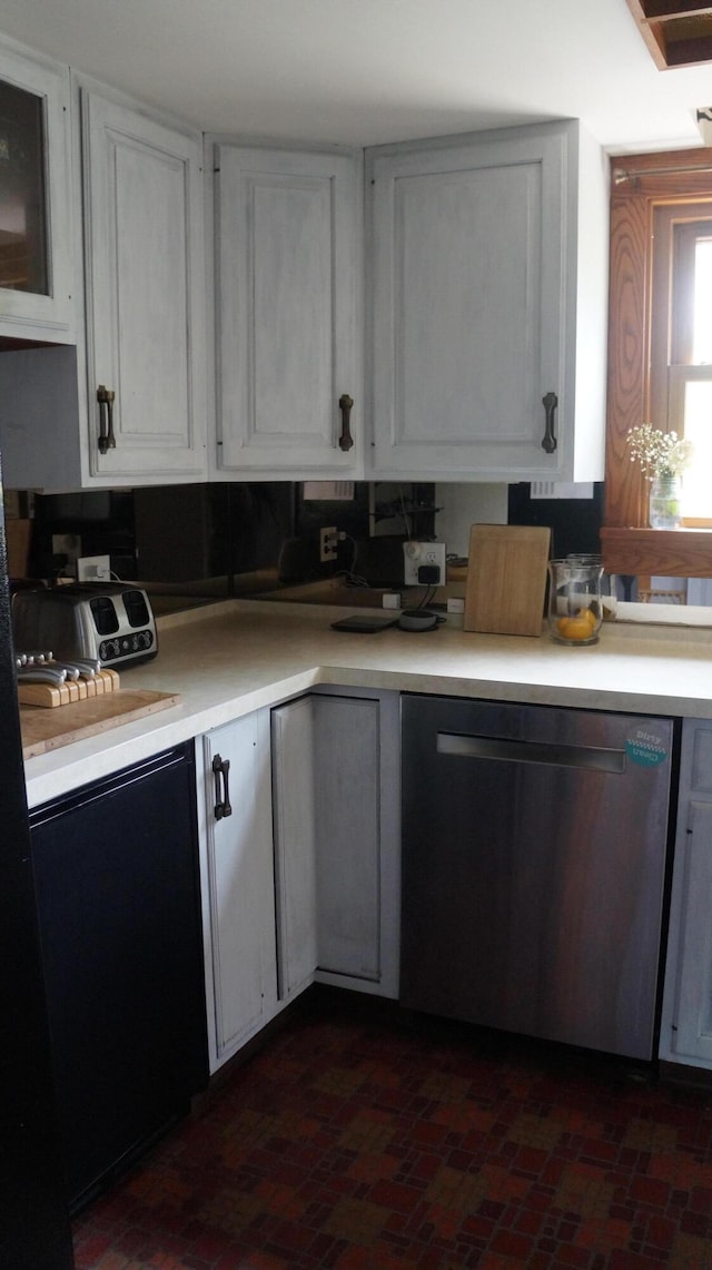 11340 Mccrone Rd, Milan, MI 48160 - kitchen featuring dishwasher, light countertops, brick patterned flooring, and white cabinets