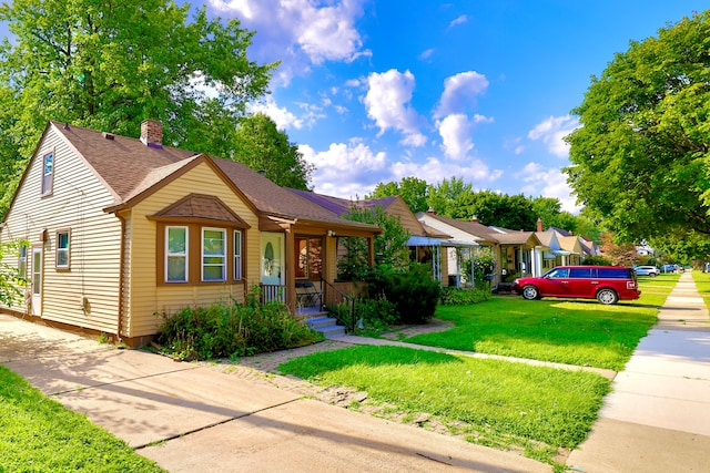 3638 Katherine St, Dearborn, MI 48124 - bungalow-style house with concrete driveway, a front yard, a chimney, and a shingled roof