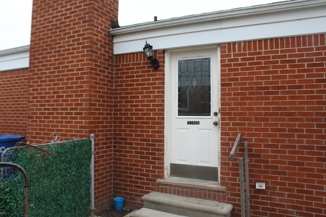 view of exterior entry featuring brick siding
