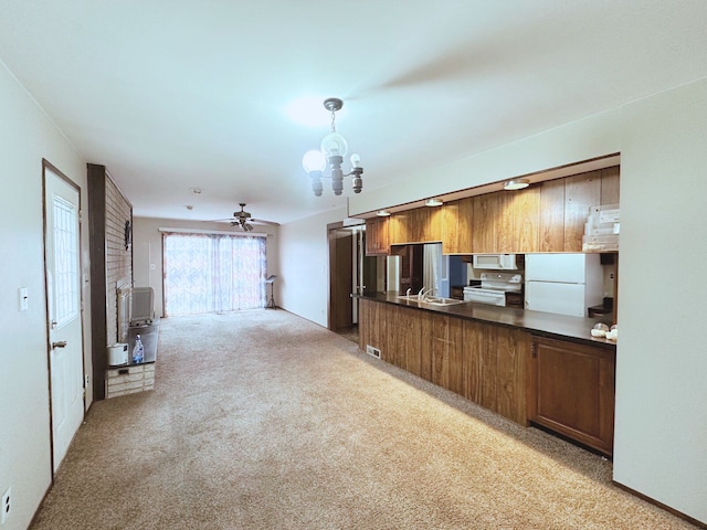 kitchen with white appliances, dark countertops, light carpet, open floor plan, and a ceiling fan
