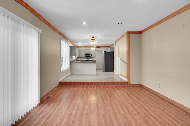 2515 N Lake Pleasant Rd, Attica, MI 48412 - unfurnished living room with crown molding, ceiling fan, light wood-style flooring, baseboards, and a sink