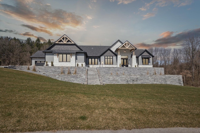 view of front of property featuring a lawn and stone siding