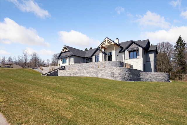 view of front of property with a front yard, stone siding, and a chimney
