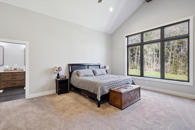 bedroom with carpet, ensuite bathroom, high vaulted ceiling, and baseboards