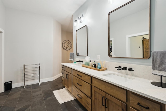 bathroom with double vanity, baseboards, and a sink