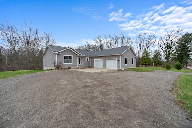 ranch-style house featuring a garage and driveway