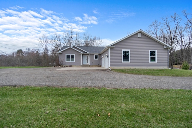 ranch-style house with a front lawn, a garage, and driveway