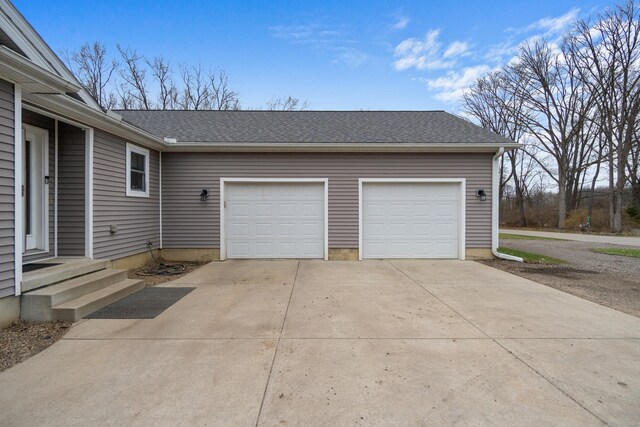 garage featuring concrete driveway