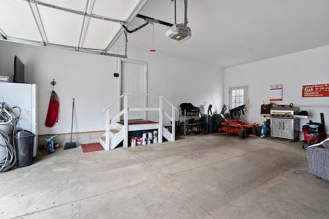 garage featuring a garage door opener and freestanding refrigerator