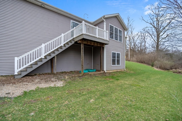 back of house featuring a lawn, a wooden deck, and stairway