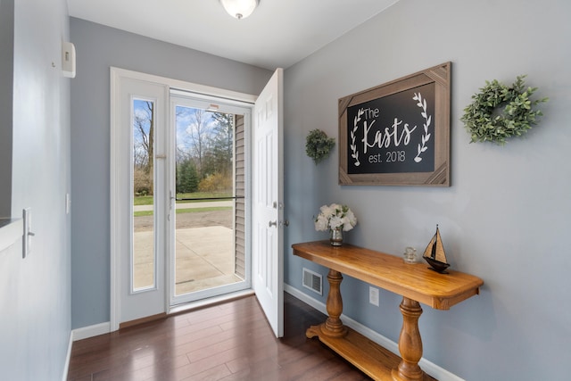 doorway to outside with visible vents, baseboards, and wood finished floors