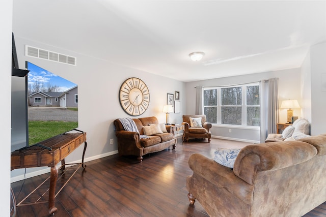 living area featuring visible vents, baseboards, and wood-type flooring