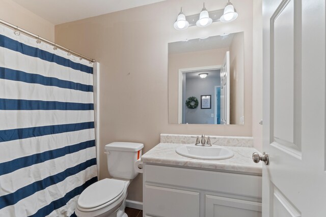bathroom featuring toilet, curtained shower, and vanity