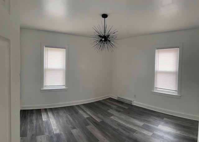 6134 Woodhall St, Detroit, MI 48224 - empty room with a chandelier, dark wood finished floors, and baseboards