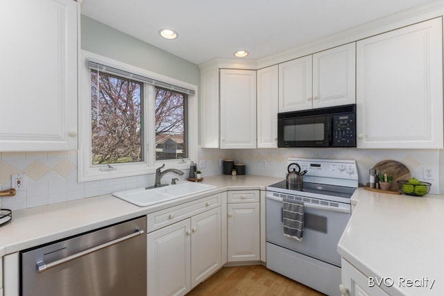 kitchen with stainless steel dishwasher, white range with electric cooktop, black microwave, white cabinetry, and a sink