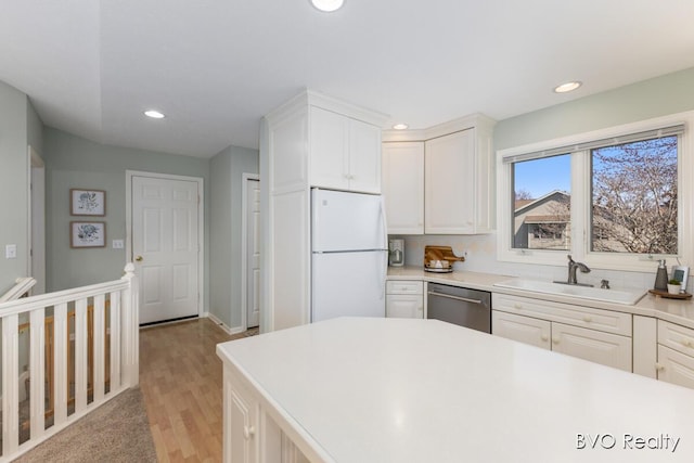 kitchen with stainless steel dishwasher, recessed lighting, a sink, and freestanding refrigerator