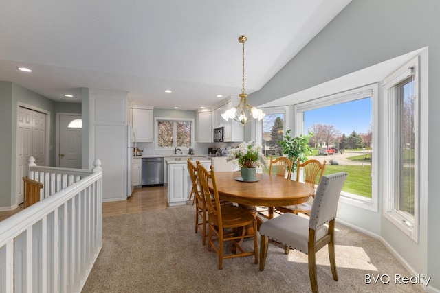 dining space featuring baseboards, light carpet, recessed lighting, a chandelier, and lofted ceiling