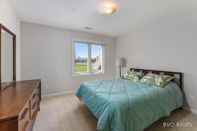bedroom with light colored carpet, baseboards, and visible vents