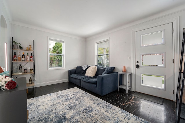 living room with a healthy amount of sunlight, arched walkways, ornamental molding, and dark wood-type flooring