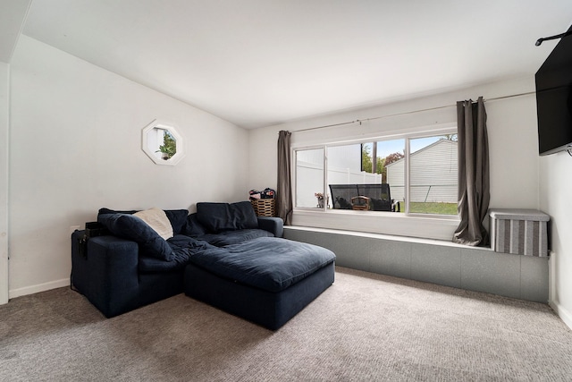 carpeted living room with baseboards and vaulted ceiling
