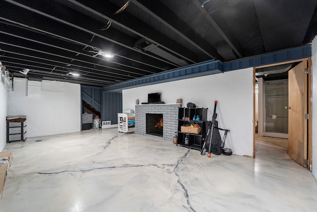 finished basement with a brick fireplace and stairs