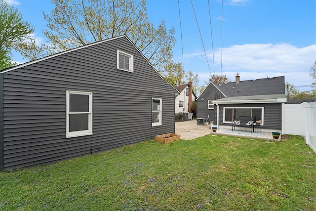 rear view of house with a patio, fence, and a yard