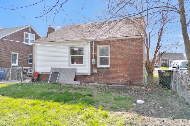 19544 Strasburg St, Detroit, MI 48205 - back of property featuring brick siding, a chimney, fence, and a shingled roof
