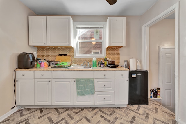 19544 Strasburg St, Detroit, MI 48205 - kitchen featuring decorative backsplash, white cabinetry, fridge, and brick patterned floor