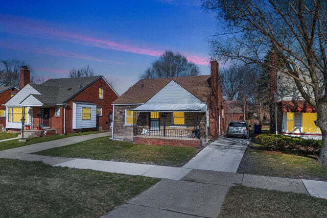 19544 Strasburg St, Detroit, MI 48205 - bungalow-style house featuring a shingled roof, a yard, stone siding, covered porch, and concrete driveway