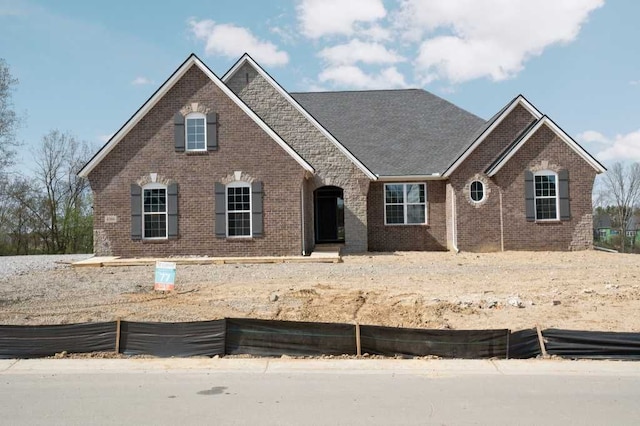 view of front of house with brick siding and fence