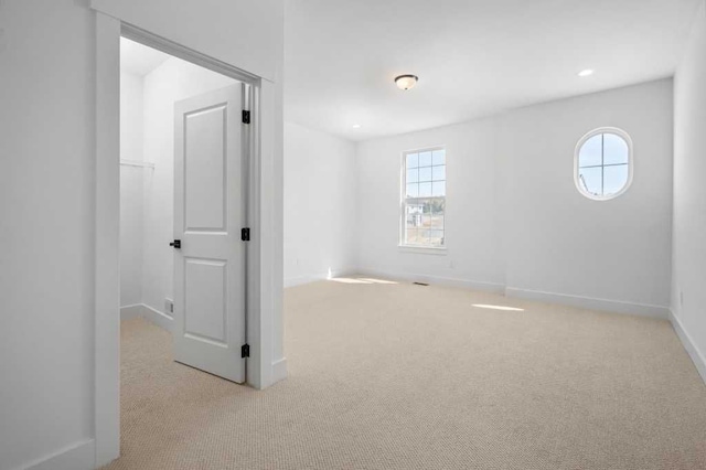 spare room with baseboards, carpet, and a wealth of natural light