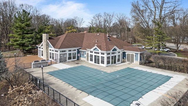 back of house featuring a fenced in pool, french doors, stone siding, a patio area, and fence