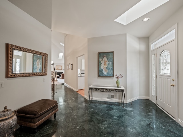 entryway with a skylight, recessed lighting, marble finish floor, and baseboards