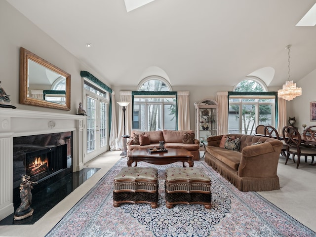 carpeted living room with a fireplace, a notable chandelier, and plenty of natural light