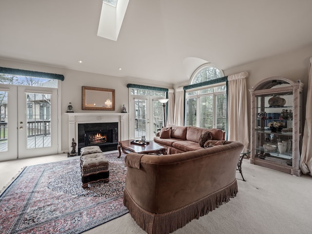 living area with light carpet, french doors, vaulted ceiling, and a premium fireplace