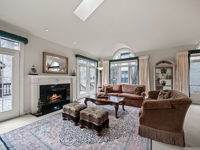living area featuring a fireplace with flush hearth, a skylight, french doors, and carpet