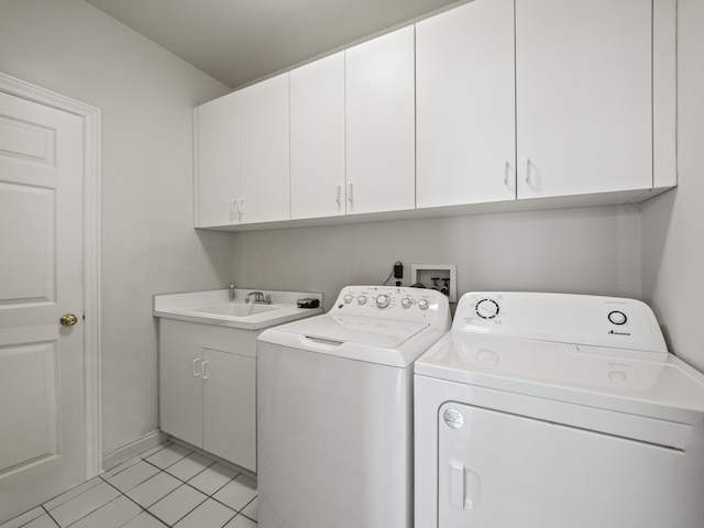 laundry area featuring baseboards, a sink, cabinet space, washer and clothes dryer, and light tile patterned flooring